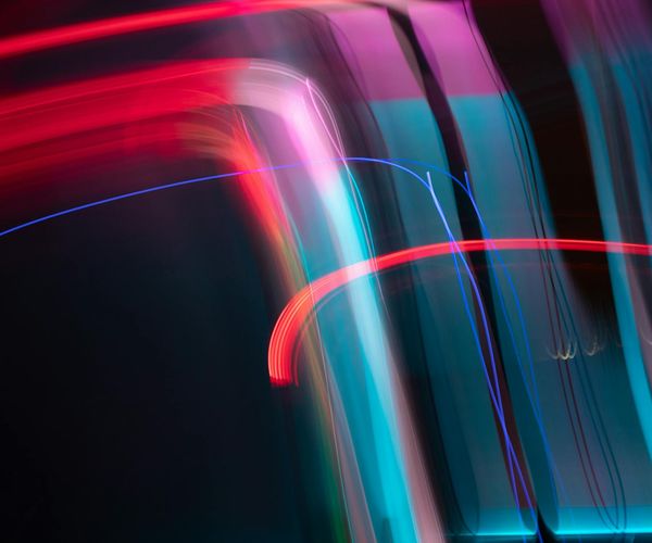 Abstract image representing clarity and focus with light streaks on dark background.